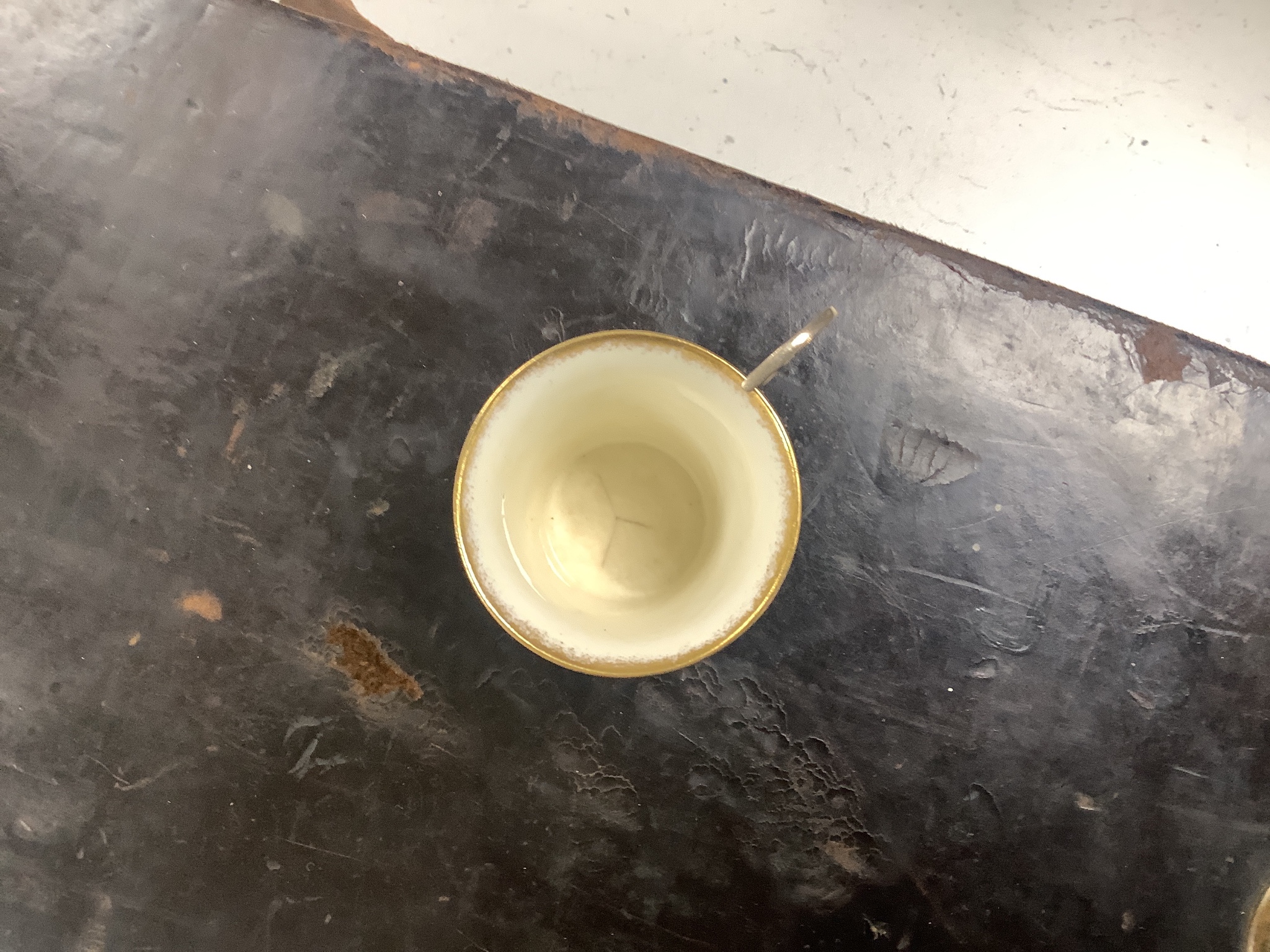 A set of six blue and gilt edged coffee cups and saucers, the cups with pierced silver holders, London, 1919, together with a set of 6 coffee spoons, triffid end terminals, Sheffield, 1925, cased